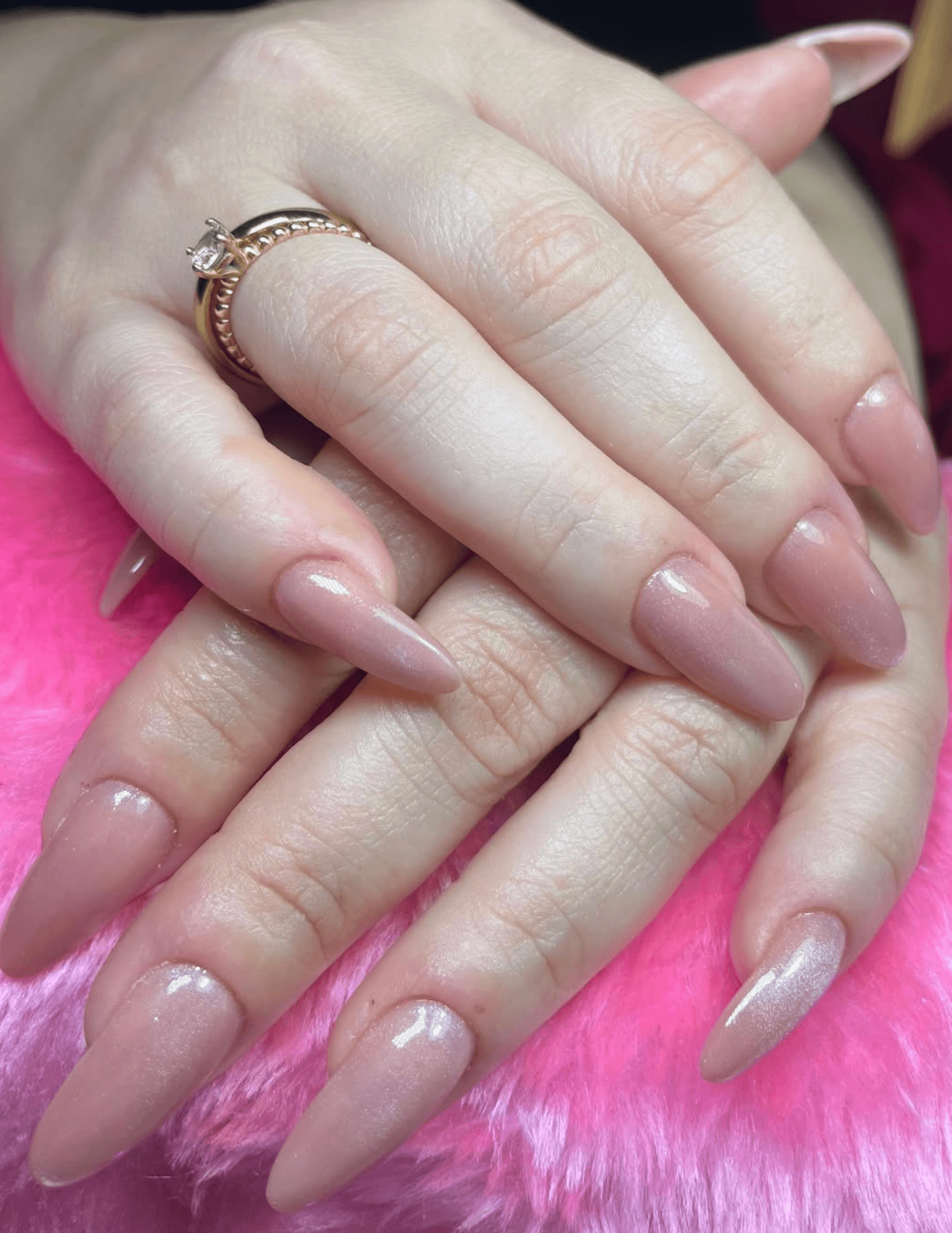 Uñas almendradas acrílicas nude blush con detalle de anillo dorado